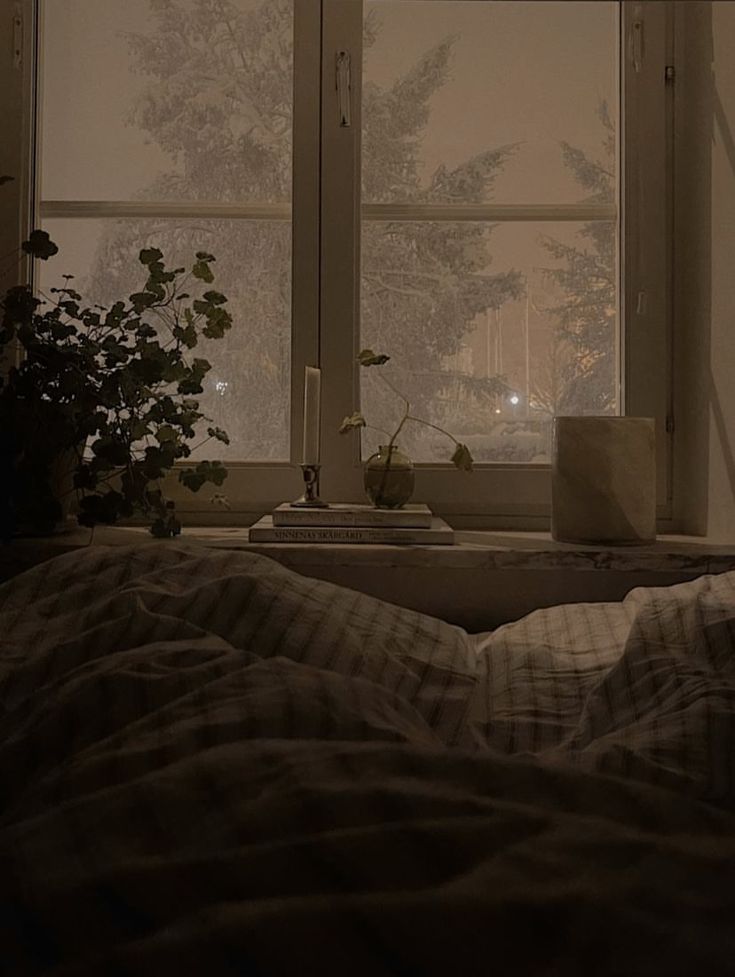 a bedroom scene with focus on an unmade bed and the night light shining through the window