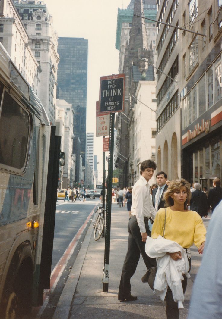 people walking down the street in front of a bus