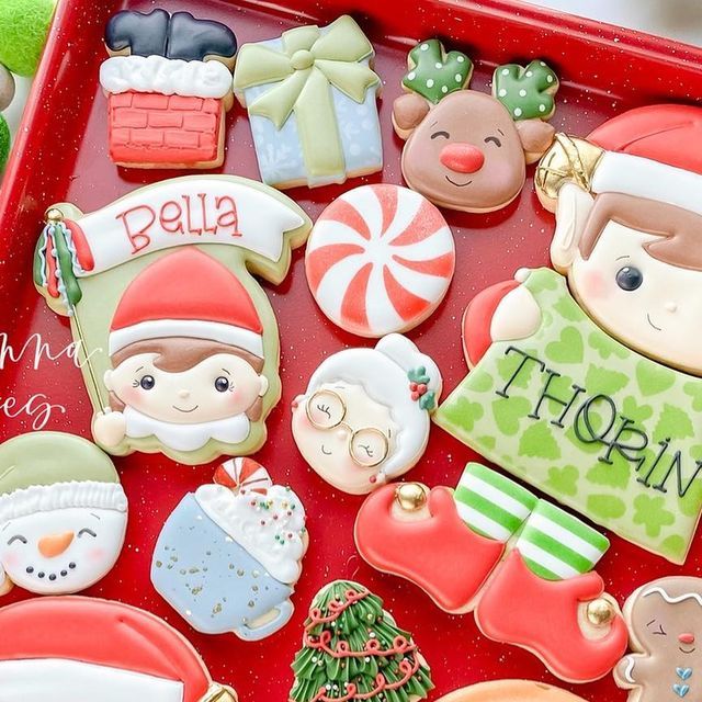 christmas cookies are on a red tray with santa's helper and other decorations