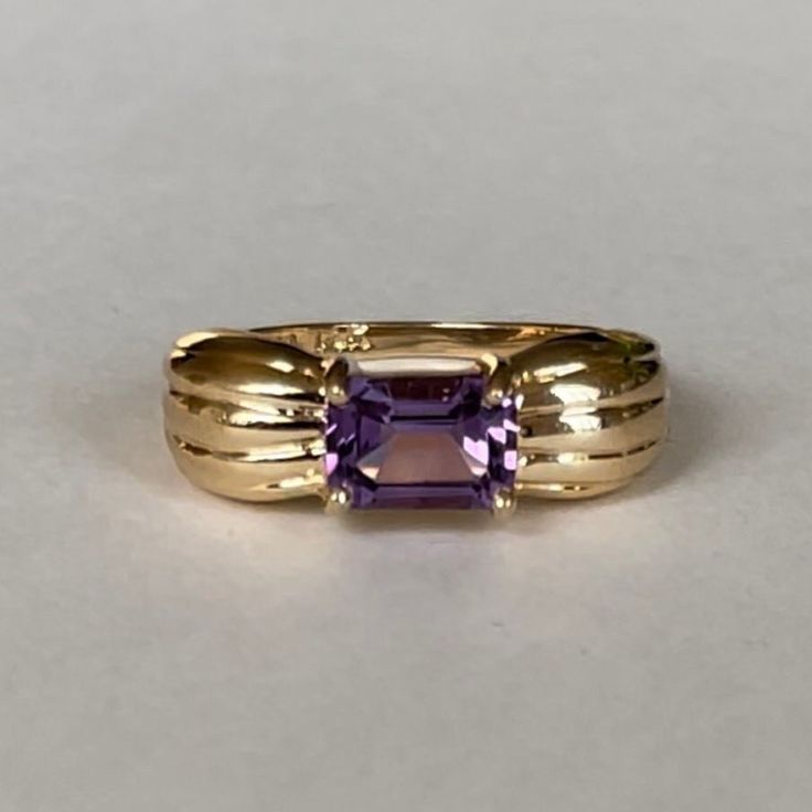 Mid Century 14K Emerald Cut Amethyst, Size 5.25, 2.3 grams, February Birthstone  Size: 5.25 Weight: 2.3grams Main Stone: Amethyst (1 stone) Size Stone: ca. 6.88mm x 4.88mm  Cut: Emerald Color: Beautiful Medium Dark Purple Marking: 10K, PINA? Band Material: 10 Karat Solid Gold Tested: Olympus Vanta GX Precious Metal Analyzer, Presidium Gemtester ll- tested Amethyst (testing performed by 3rd party) Condition: Excellent preowned- very light wear out throughout - Refer to picture for condition. All Emerald Color, February Birth Stone, Emerald Cut, Precious Metals, Little Gifts, Rings Statement, Emerald, Solid Gold, Statement Rings