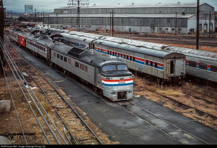 two trains are parked next to each other on the tracks in an abandoned train yard