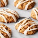 freshly baked cookies with white icing on a baking sheet, ready to be eaten