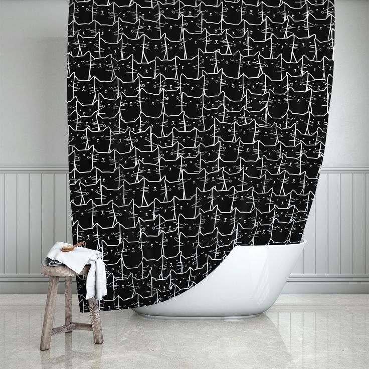 a black and white shower curtain with cats drawn on it in front of a bathtub