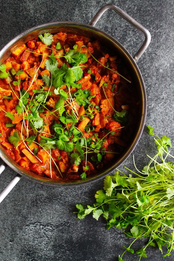 a pan filled with food sitting on top of a table next to some parsley