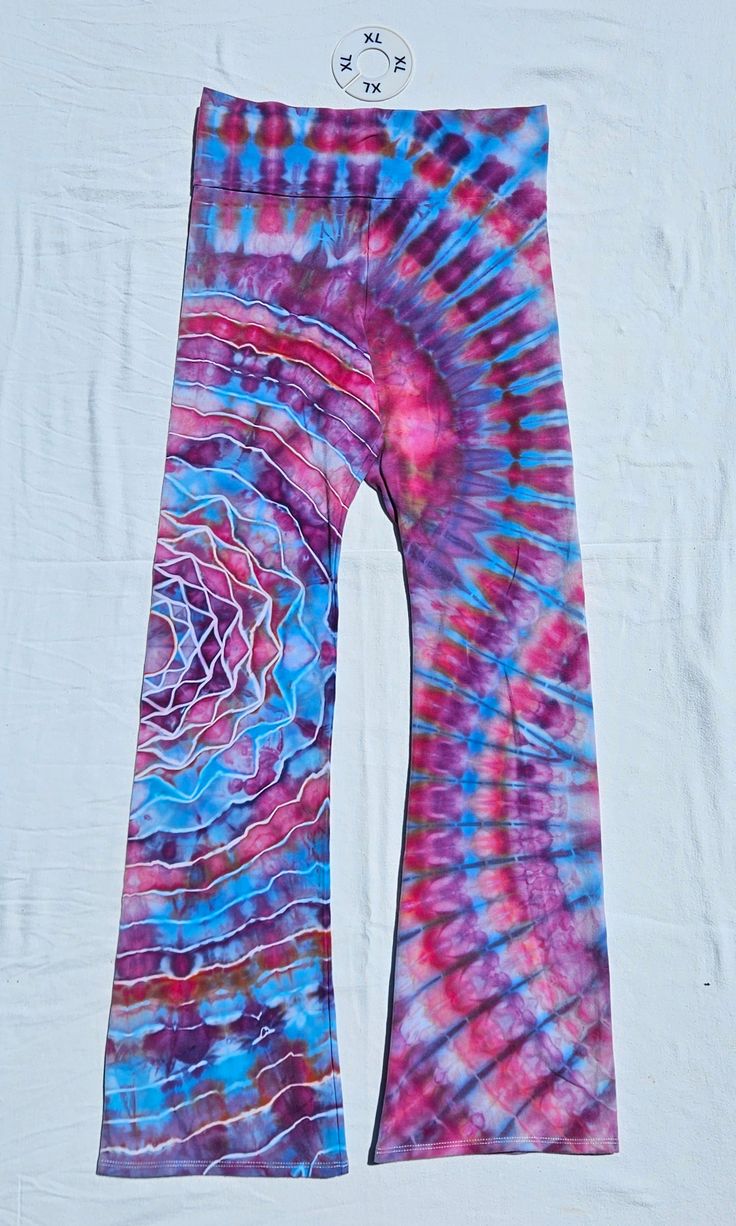 a tie - dyed pair of pants with a clock on the wall in the background