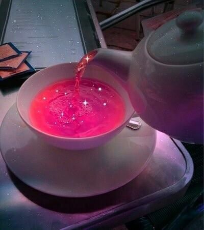 a tea pot pouring pink liquid into a white bowl