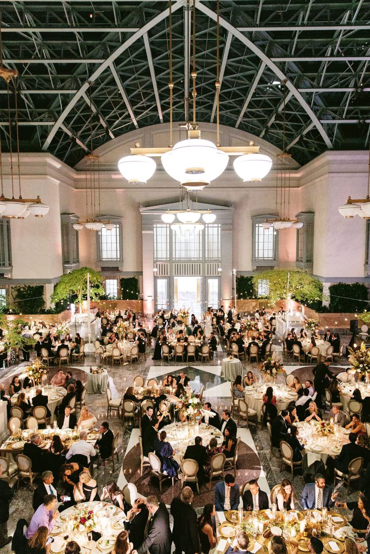 a large room filled with lots of people sitting at tables