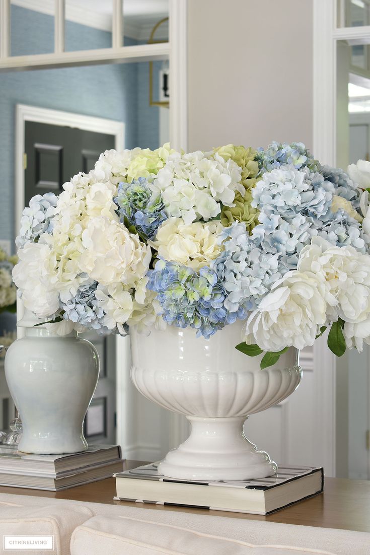 a white vase filled with blue and white flowers