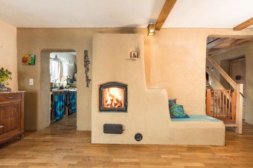 a living room filled with furniture and a fire place in the middle of it's wall