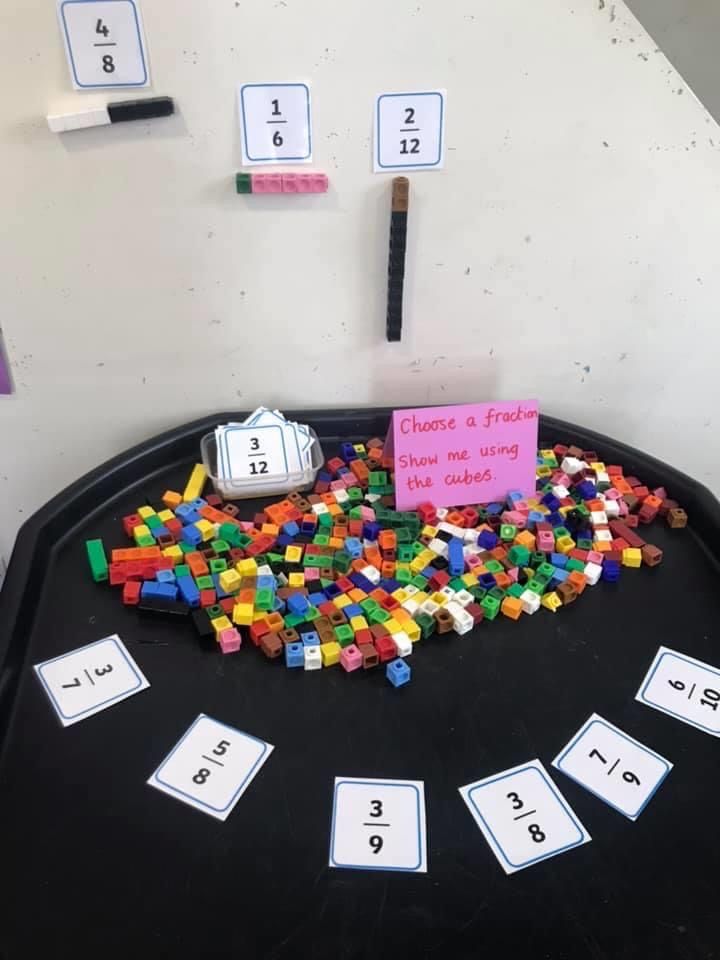 a black table topped with lots of legos next to numbers and a pink sign