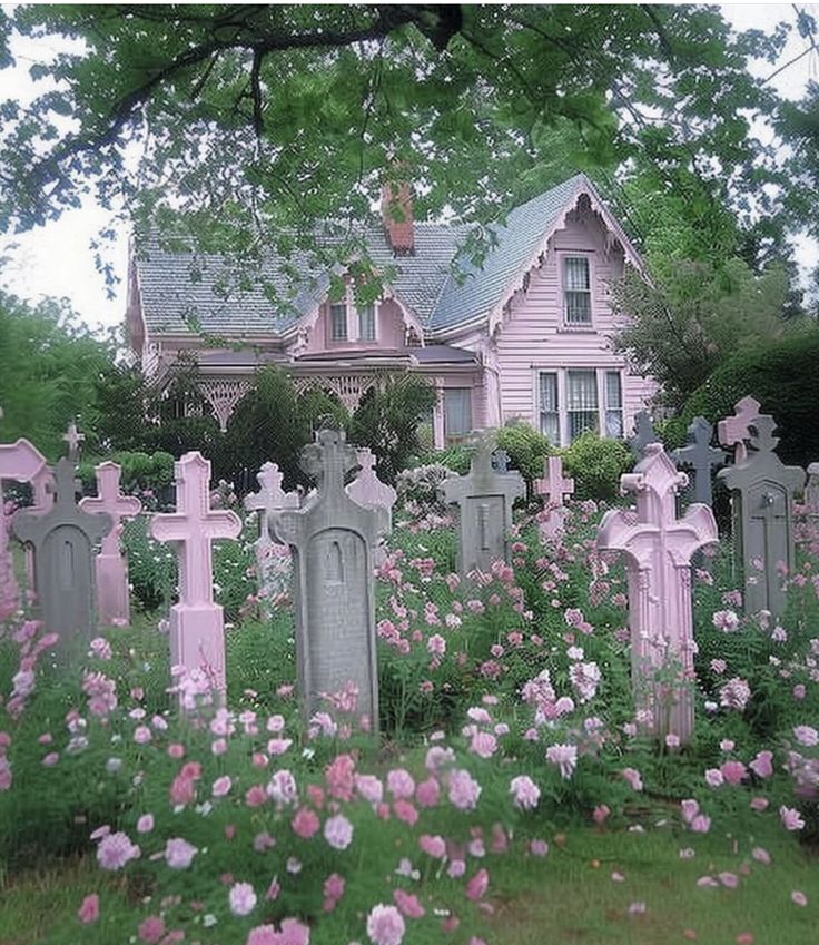 a cemetery in front of a house with pink flowers growing around the headstones