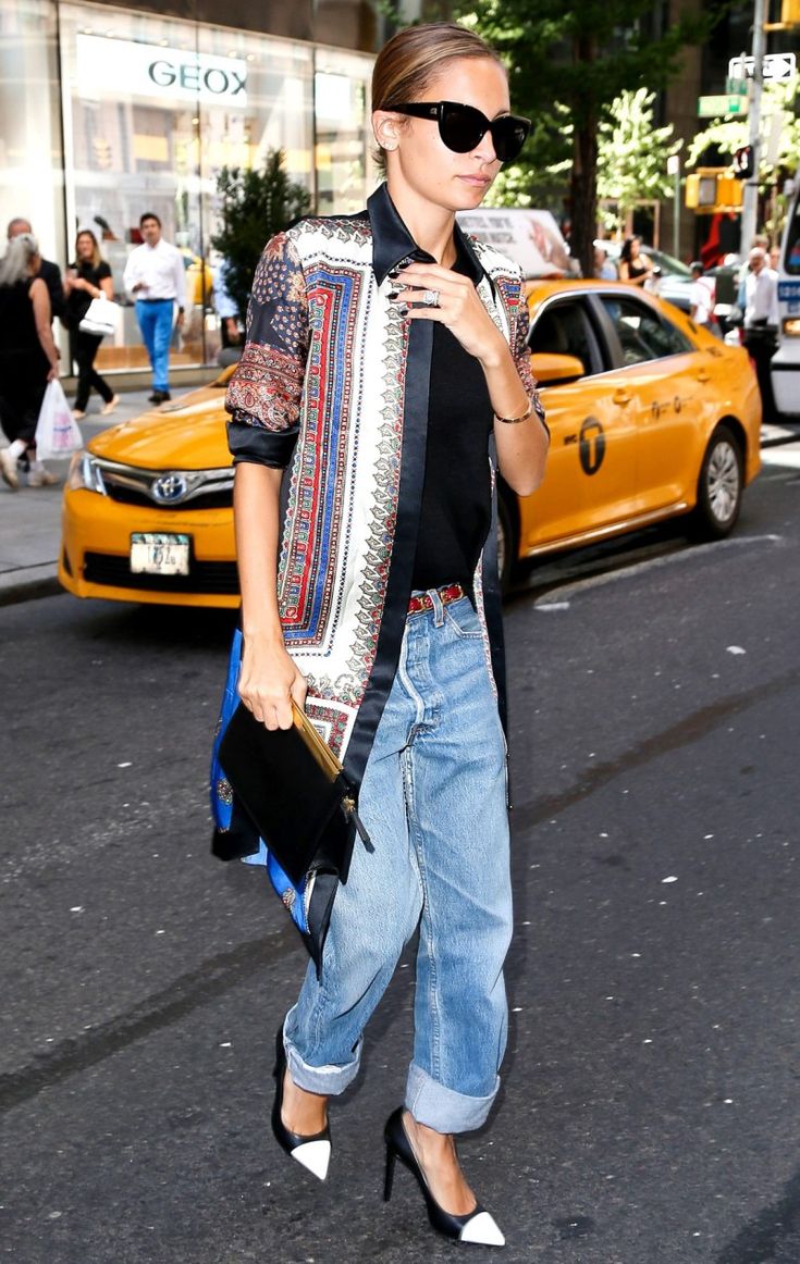 a woman walking down the street with her hand in her pocket and wearing high heels