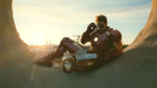 a man dressed as iron man sitting on the ground