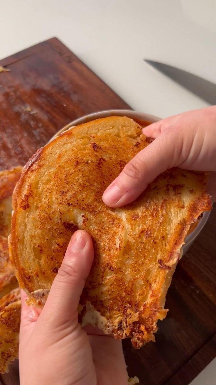 a person holding a piece of food in their hand while they are about to eat it