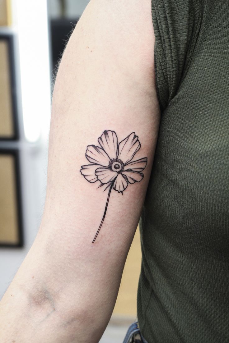 a black and white flower tattoo on the arm