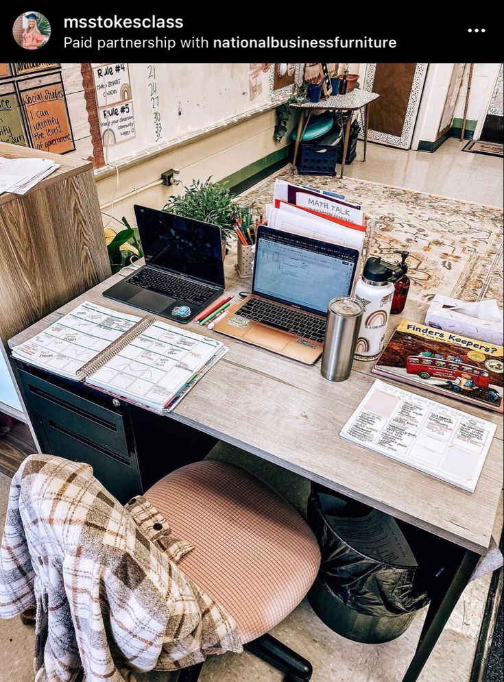 there is a desk that has two laptops on it and papers all over the table