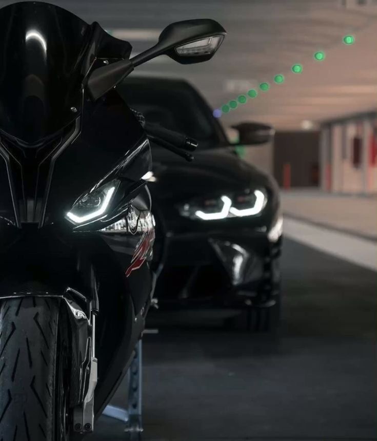 two motorcycles parked next to each other in a parking garage with green lights on them