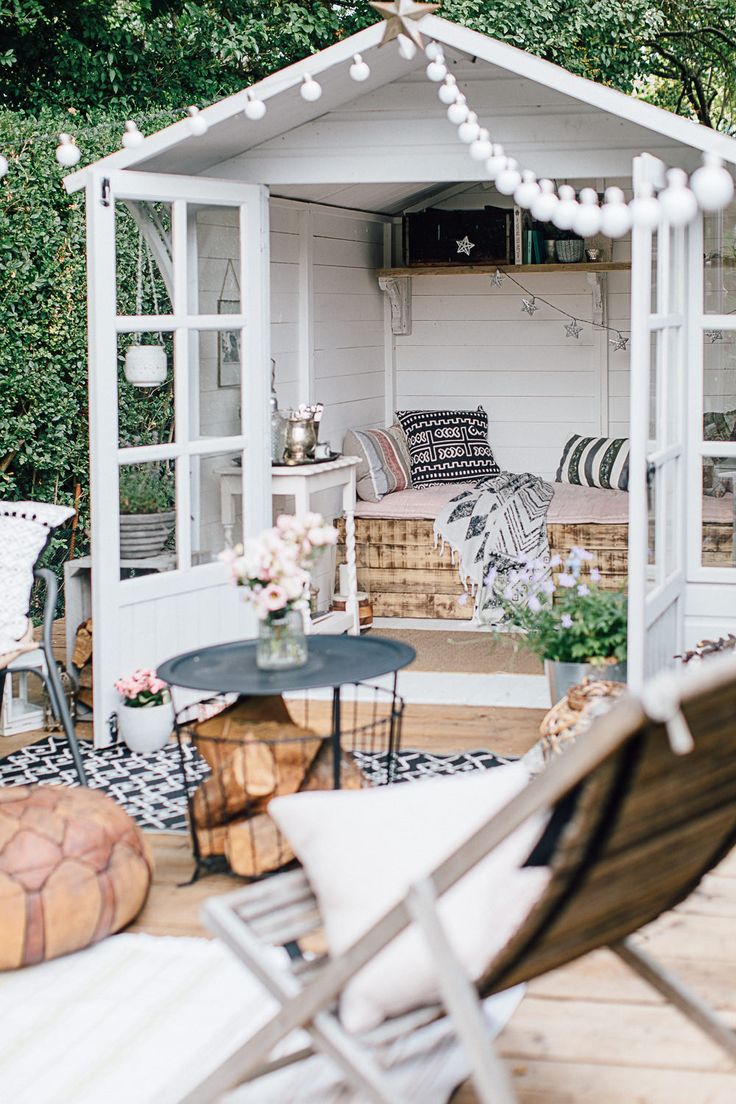 an outdoor living area with chairs, tables and a gazebo in the middle of it