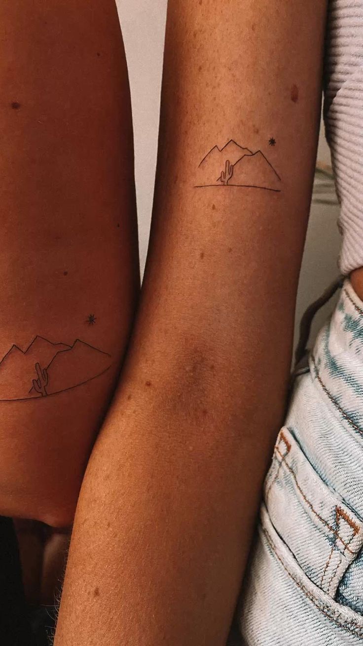 two people with matching tattoos on their arms