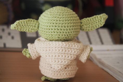 a crocheted yoda doll sitting on top of a table