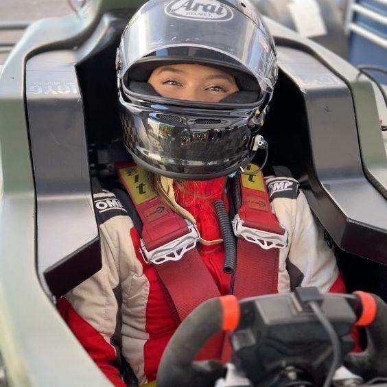 a woman in a racing car wearing a helmet