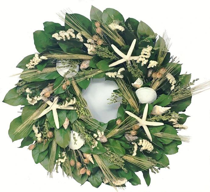 a wreath with starfishs, seashells and greenery is displayed on a white background