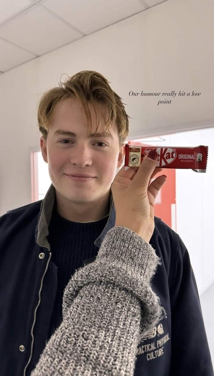 a young man holding up a tube of toothpaste