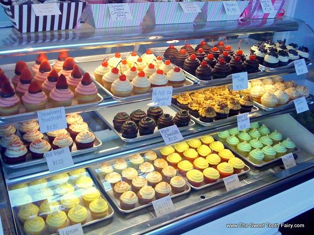 a display case filled with lots of different types of cupcakes and pastries