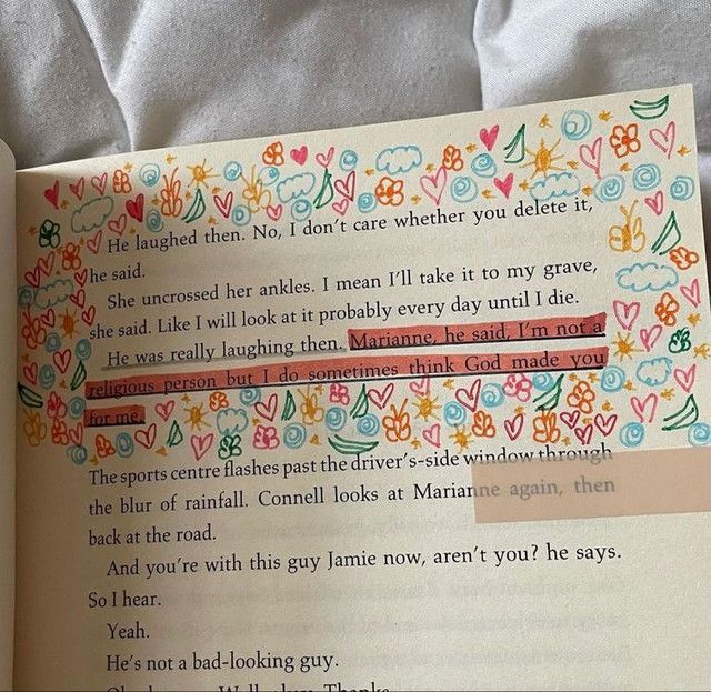 an open book with some writing on the page and flowers in it, sitting on a bed