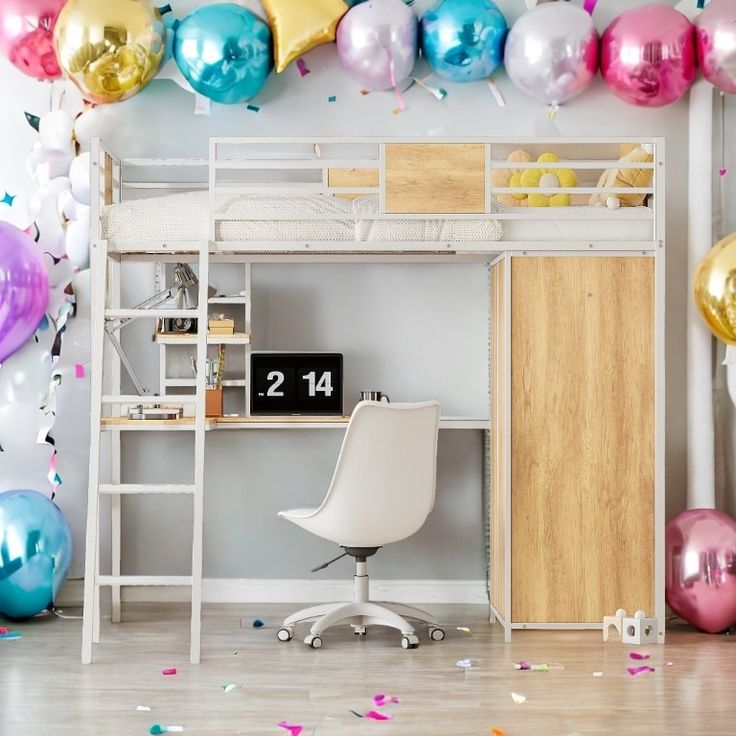 a room with balloons and a desk in front of the wall that has a ladder on it