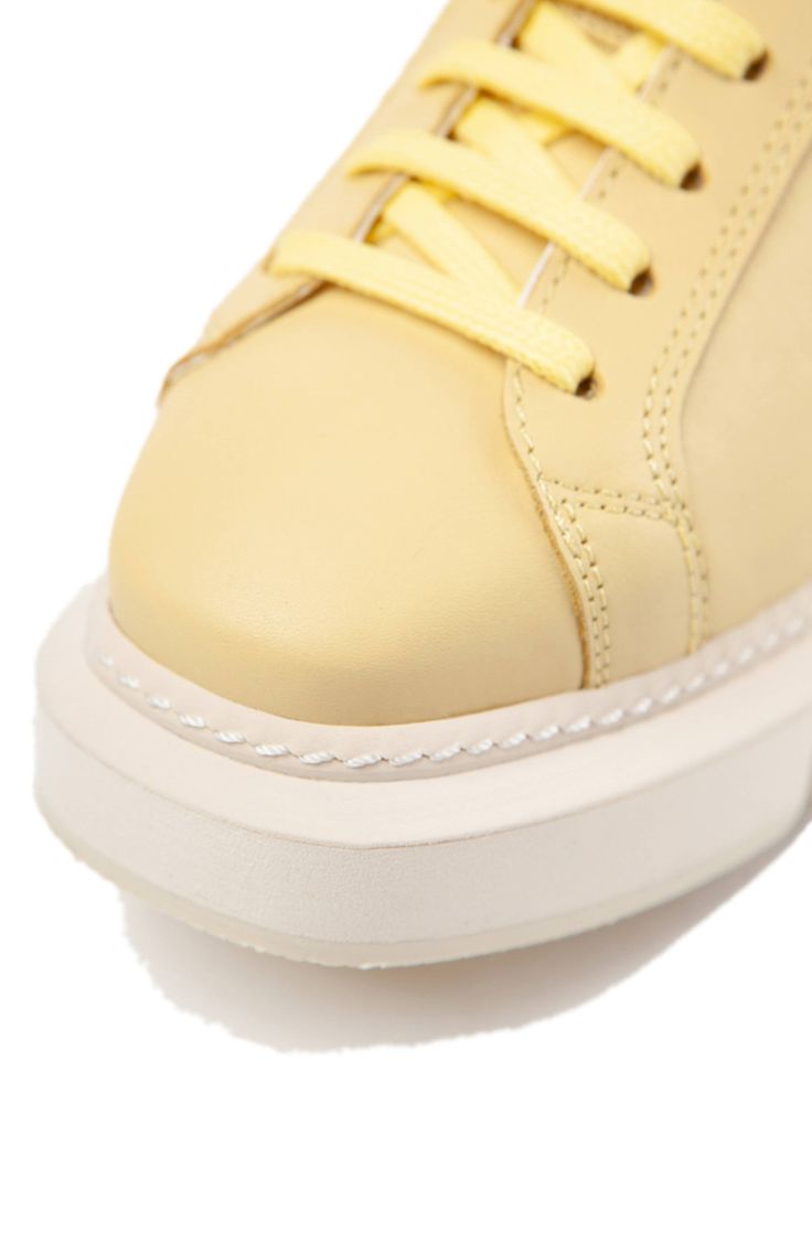 A chunky platform brings luxe drama to a sporty-chic lace-up sneaker made in Spain from high-quality leather and finished with a cool contrast detail at the heel. Lace-up style Leather upper and lining/synthetic sole Made in Spain Paloma Barcelo, Chunky Platform, Pastel Yellow, Sporty Chic, Paloma, Up Styles, High Quality Leather, Womens Sneakers, Leather Upper