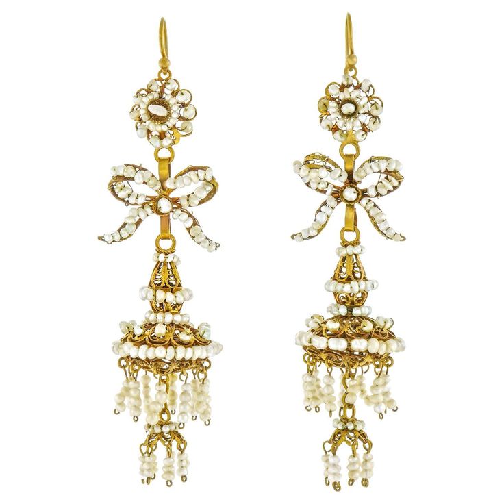 Circa 1870s, 18k, Iberian. Featuring long elegant lines jazzed with flirty movement, these chandelier earrings are vintage fashion at its antique best. Finely made in 18k gold and festooned with natural pearls, they are perfect hippie chic or ballroom ready! Excellent condition. Remark: "One of our favorite pair of earrings, they are are simply exciting!” SIZE: 2 1/2 inches long WEIGHT: 10.6 grams total STONES: Natural pearls HALLMARKS: None, tested 18k STOCK NUMBER: 24732 Jewelry acquired from Ruby Diamond Pendant, Style Hippie Chic, Pearl Chandelier Earrings, Pearl Chandelier, Diamond Bows, Antique Chandelier, Van Cleef Arpels, Moda Vintage, Dream Jewelry