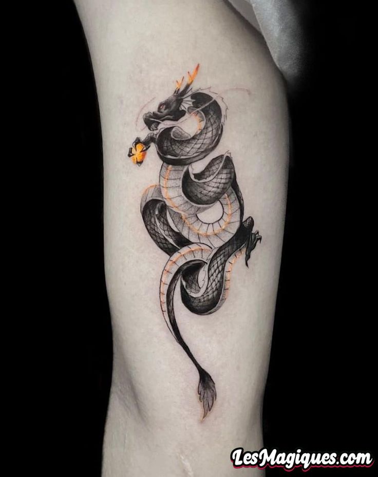 a black and white snake tattoo on the right thigh, with an orange flower in its mouth