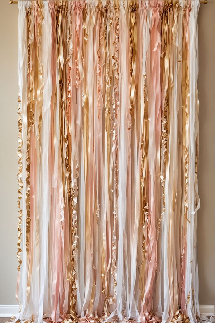 a curtain with gold and pink ribbons hanging from it's side in front of a beige wall