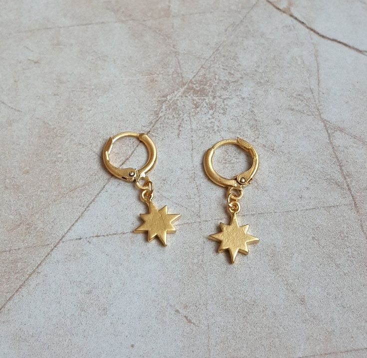 🌙 Pair of handcrafted 14k gold plated north star charm on 14k gold plated huggie hoop earrings 🌙 Best gift for your friends and family or just for yourself 🌙 Regular shipping takes approximately 10-15 business days depending on your country. Express shipping takes 3-5 business days. Please choose express shipping if you want to receive your package faster 🌙 I do offer combined shipping. Please feel free to contact me for custom orders and combined shipping orders 🌙 Although my products are durable and tarnish free, you better keep them away from excessive water and chemicals, perfumes etc. 🌙 For more jewelries don't forget to check my store: https://www.etsy.com/shop/MiniMoonDesign 14k Gold Filled Earrings With Star Charm As Gift, Dainty Gold Plated Nickel Free Huggie Earrings, Dainty 14k Gold-filled Dangle Huggie Earrings, Dainty 14k Gold Filled Dangle Huggie Earrings, Minimalist 14k Gold-filled Charm Earrings, Nickel-free 14k Gold-filled Huggie Earrings, Minimalist 14k Gold Filled Charm Earrings, Hypoallergenic 14k Gold Filled Star Jewelry, Handmade Dainty Huggie Earrings