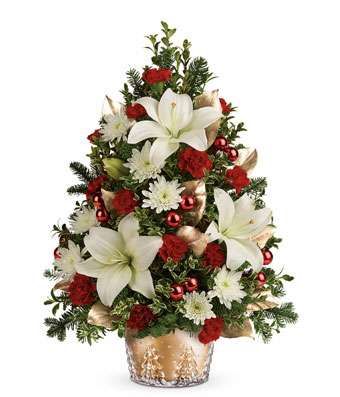 a christmas tree arrangement with white lilies and red carnations in a glass vase