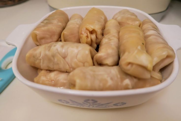 a white bowl filled with dumplings on top of a table