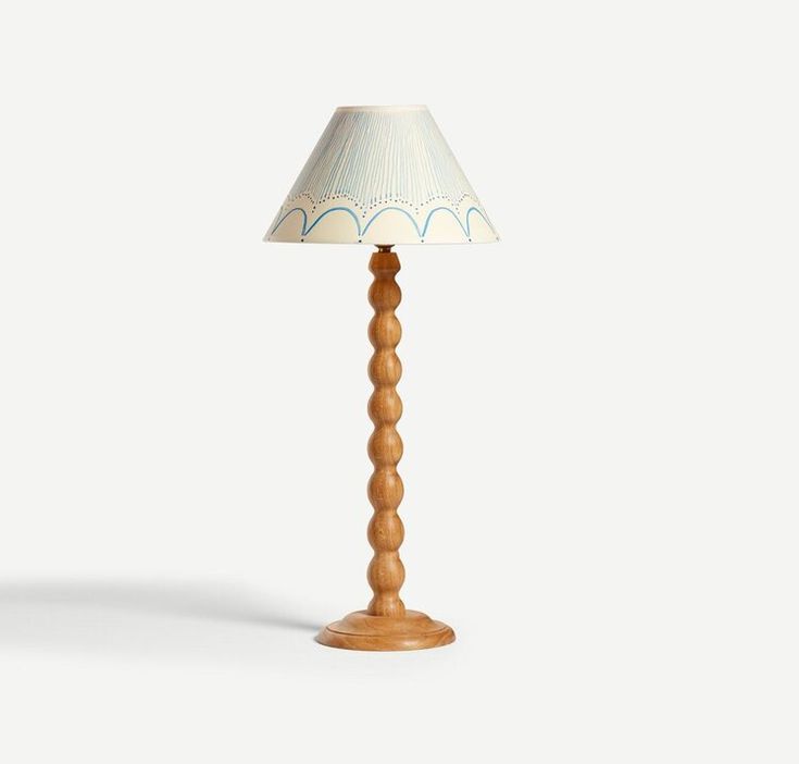 a wooden lamp with a white shade on it