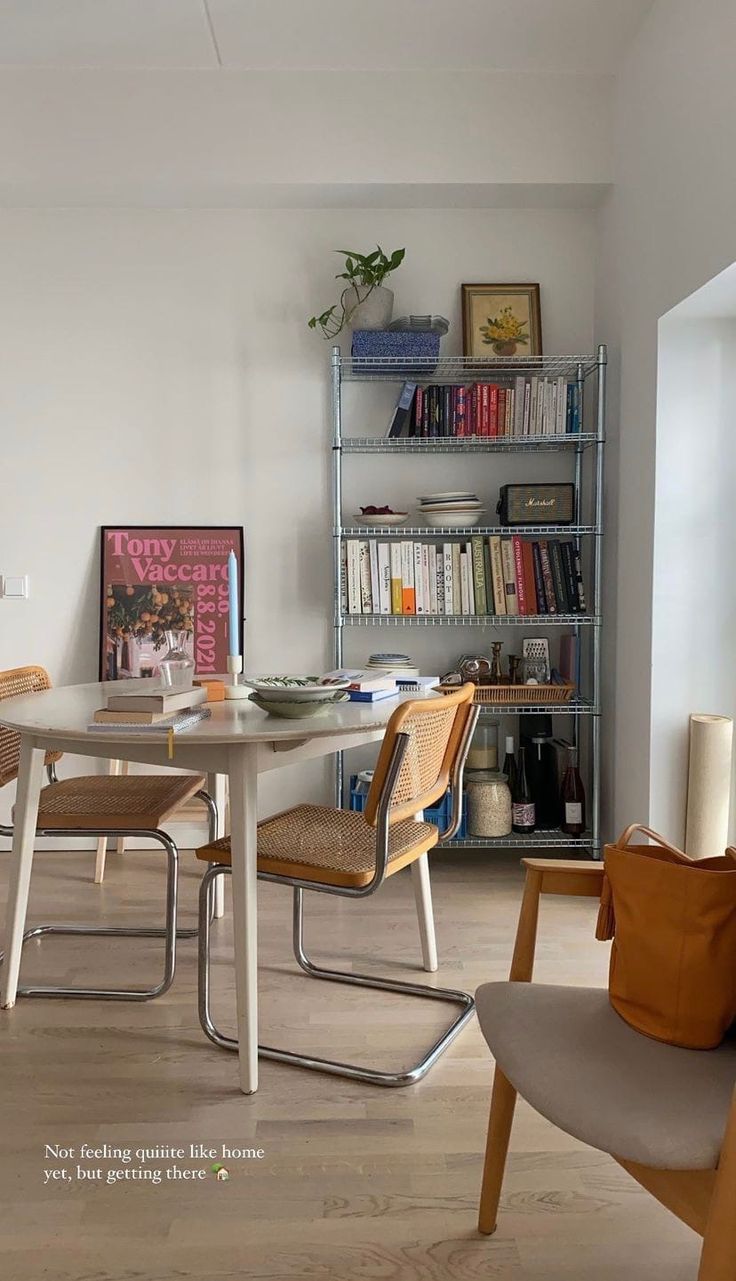 a dining room table and chairs with bookshelves in the background on a hard wood floor