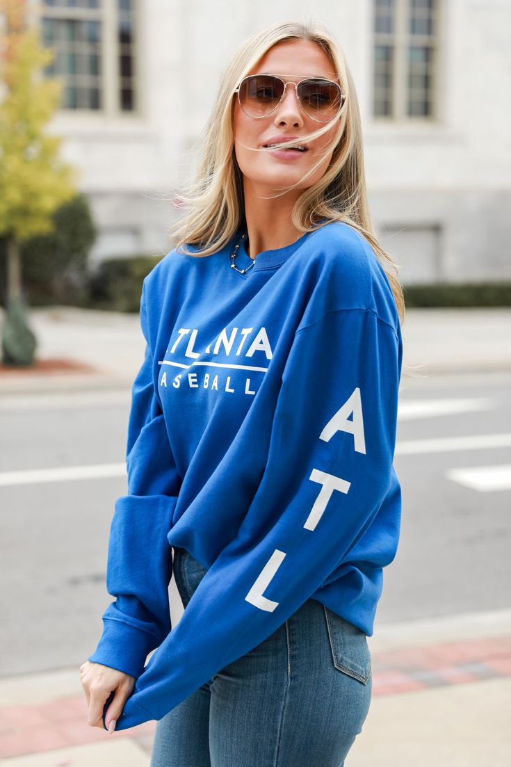 Calling all Braves fans, the Royal Blue Atlanta Baseball Pullover was made just for you! This comfy sweatshirt is designed with a soft and stretchy knit with a fleece interior. It features a crew neckline, long sleeves with "ATL", a relaxed fit, and the words "Atlanta Baseball" on the front. Style the Royal Blue Atlanta Baseball Pullover with your favorite denim and a baseball hat for a game day look! Soft + Stretchy Knit Fabrication Fleece Interior "Blue Atlanta Baseball" Graphic Crew Neckline Fan Apparel Long Sleeve Sweatshirt With Ribbed Cuffs, Fan Apparel Sweatshirt With Ribbed Cuffs, Blue Crew Neck Sweats For Spring, Fan Apparel Long Sleeve Sweatshirt For Fall, Fan Apparel Long Sleeve Sweater With Ribbed Cuffs, Fan Apparel Sweater With Ribbed Cuffs, Blue Sweats With Ribbed Cuffs For Spring, Long Sleeve Sweater With Ribbed Cuffs For Game Day, Long Sleeve Sweater With Ribbed Cuffs For Fans