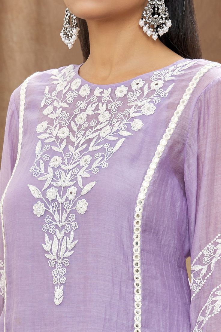 Lilac mulmul chanderi kurta with white thread embroidery, mirror work embellishment and side slits. Paired with a cotton embroidered Pakistani salwar, lehriya crinkled dupatta and sleeveless slip.
Component: 4
Pattern: Embellishment and Embroidered
Type Of Work: Mirror and Thread Work
Neckline: Round
Sleeve Type: Three Quarter
Fabric: Kurta: Mulmul Chanderi, Cotton
Color: Purple
Other Details: 
Gota work stripes on dupatta
Pom-Poms tassels on sleeves hem
Tasselled dupatta
Occasion: Puja - Aza Fa Chanderi Kurta Designs, White Thread Embroidery, Embroidery Kurtis, Plain Kurti Designs, Embroidery Kurta, Embroidery Mirror, Embroidery Boutique, Pakistani Salwar, Purple Mirror