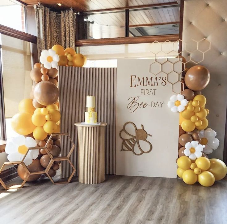 a room decorated with balloons and honeycombs