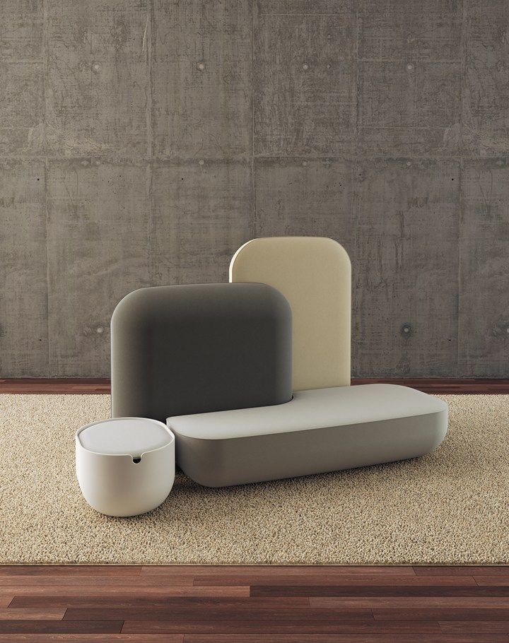 three different colored furniture sitting on top of a wooden floor next to a concrete wall