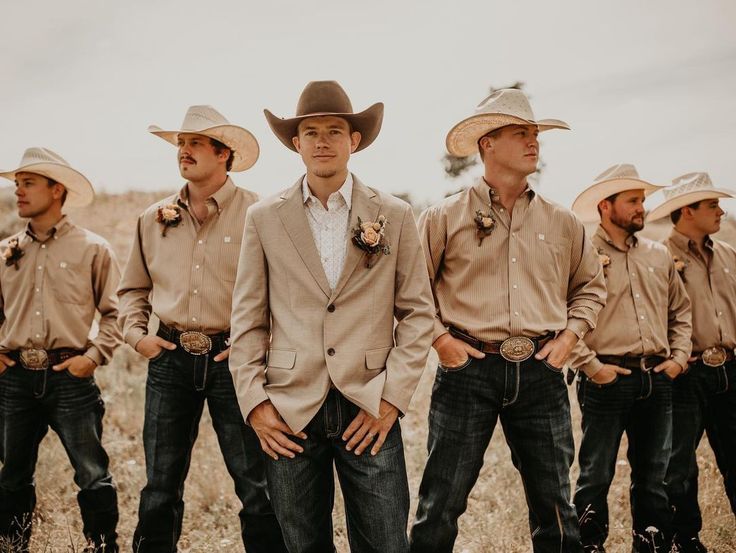 a group of men standing next to each other wearing cowboy hats