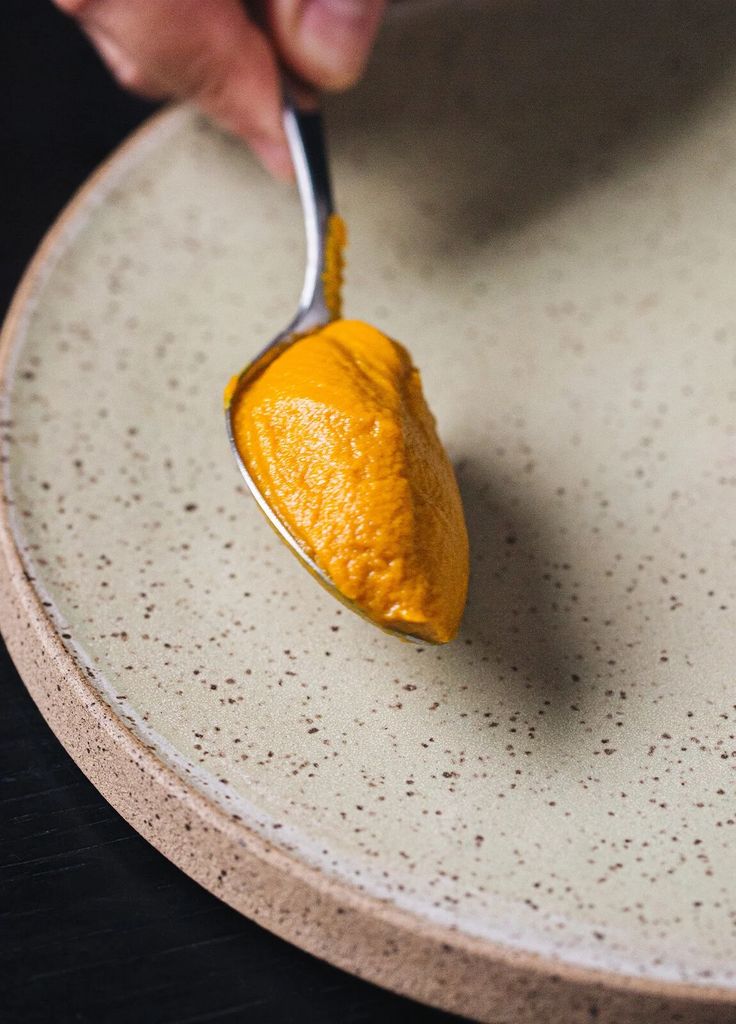 a person is spooning some food on a plate