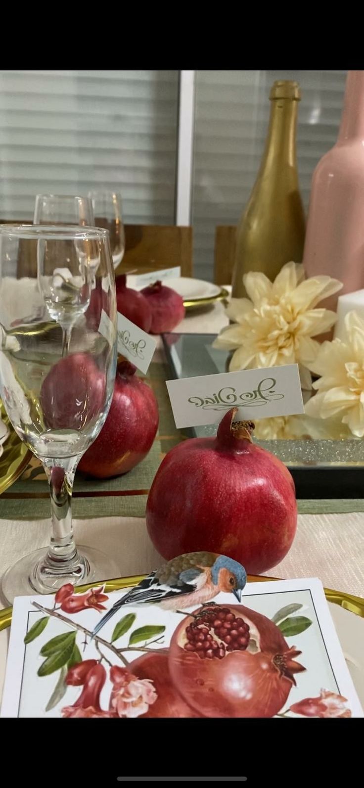 there are two wine glasses and an apple on the table next to each other,