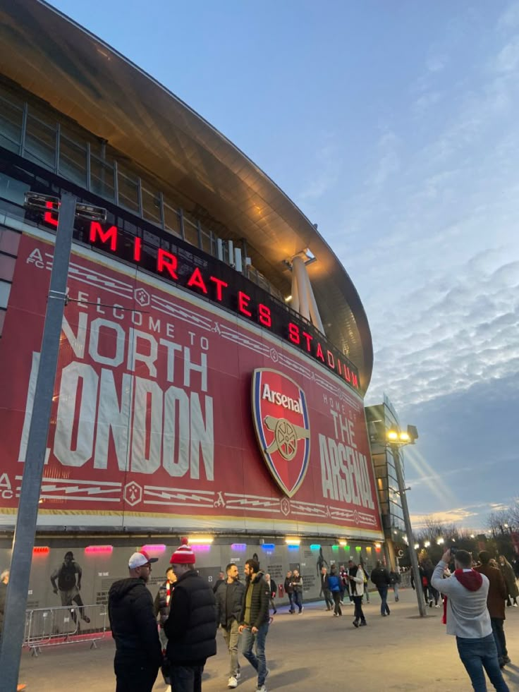 people are walking around in front of the emirates stadium