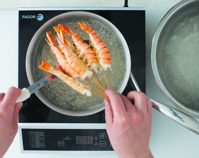 the person is cooking some food on the stove with utensils in front of them