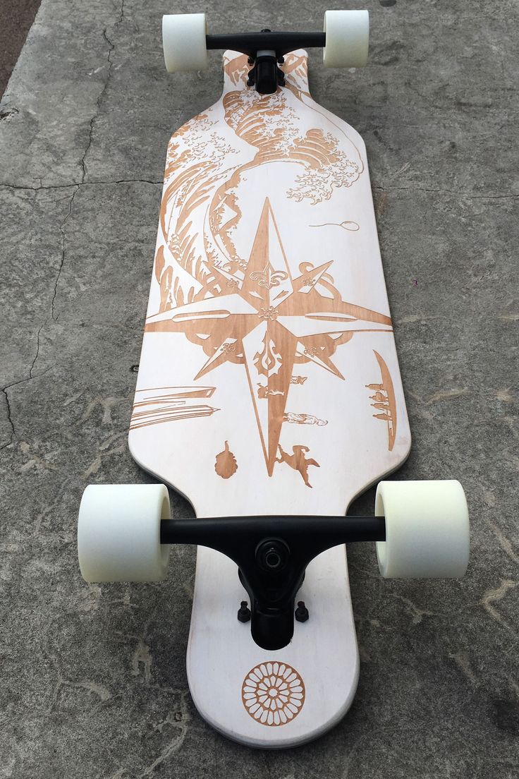 a skateboard with an orange and white design on the front is laying on concrete