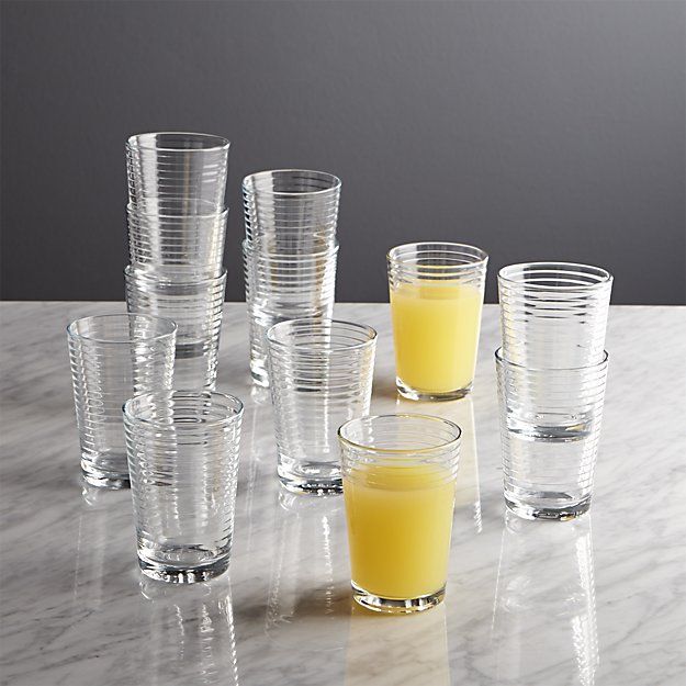 there are many glasses on the table with orange juice in them and one is empty